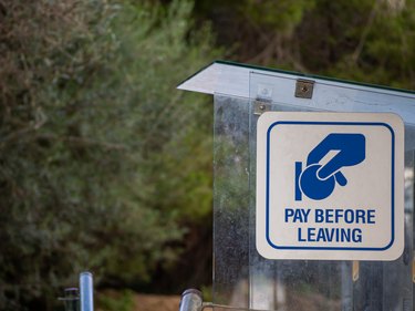 Sign in a parking lot that says "pay before leaving"