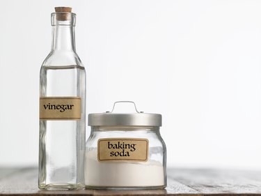 Close-Up Of Baking Soda And Vinegar On Table Against White Background