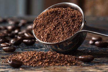 Close-Up Of Ground Coffee In Measuring Cup On Table