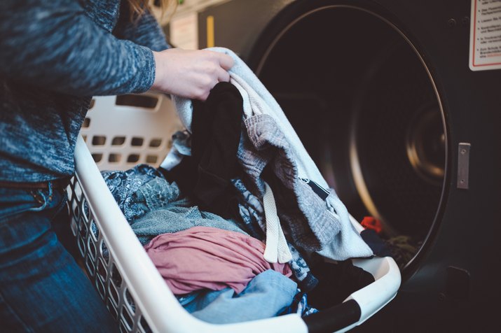 Close-up of a woman with a laundry basket washing clothes