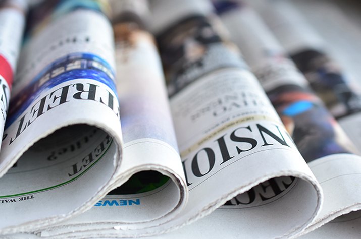 An image of newspapers laid out on a table.