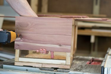 Secure the cedar planks to the side of the interior support - starting with the sides.