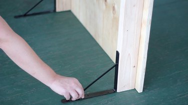 Attaching shelf brackets to bottom of fireplace cover