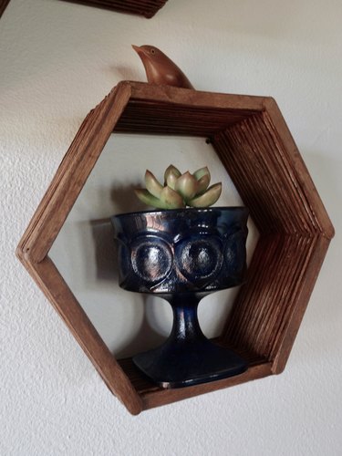 DIY hexagon, honeycomb shelves made using popsicle sticks, hot glue, and wood stain.