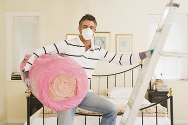 Man with bundle of roof insulation