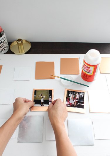 Person gluing photos to metal squares