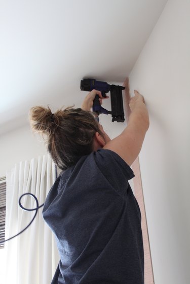 Using a nail gun to attach the planks