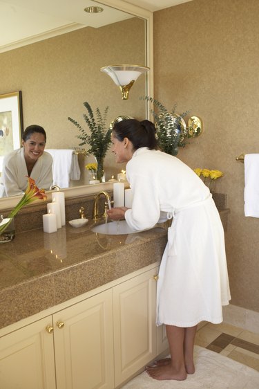 Woman standing at sink in bathroom