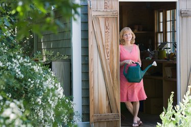 Woman with watering can posing in doorway