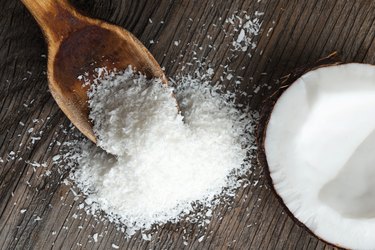 Coconut and coconut flour on wood, close up